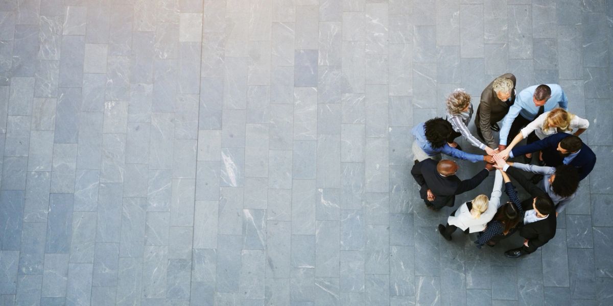 A diverse group of people joining hands in a circle